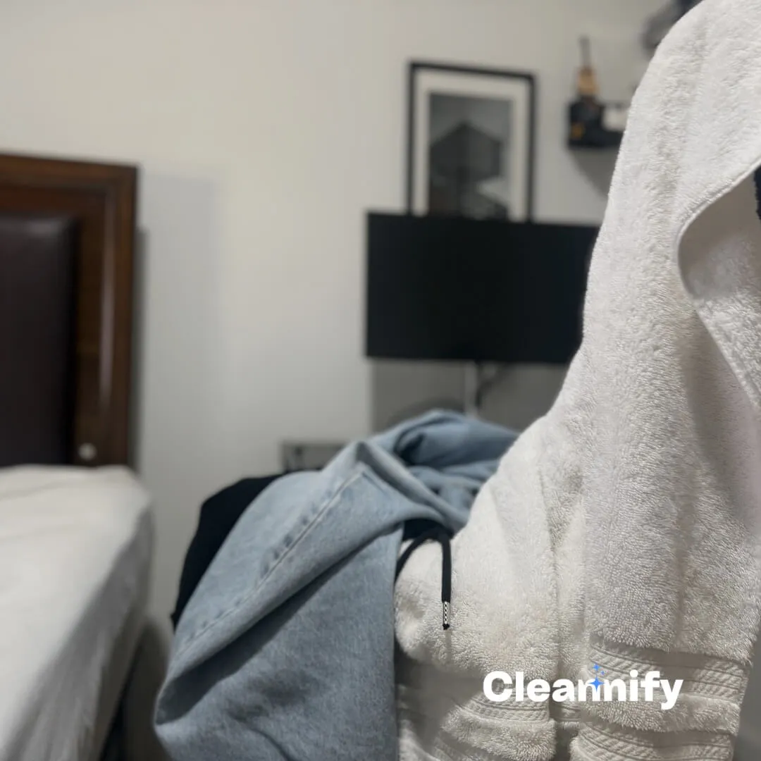 Before bedroom cleaning in Charlotte showing clothes on a chair