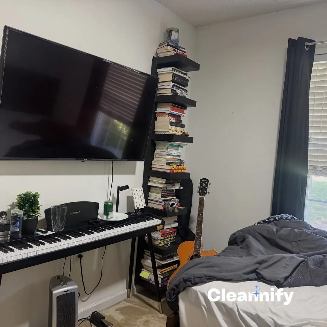 Before bedroom cleaning in Charlotte showing a TV wall, keyboard, guitar, and unmade bed