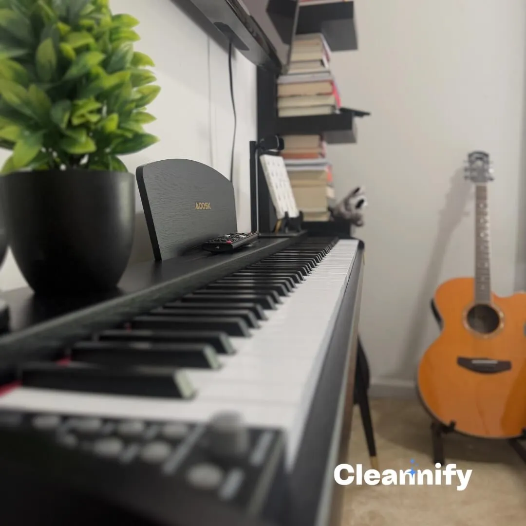 After dusting a bedroom piano surface during a residential cleaning service