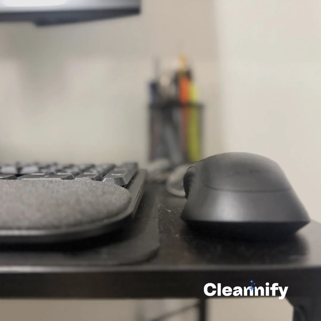 Before home office cleaning in Charlotte showing dust on a black desk